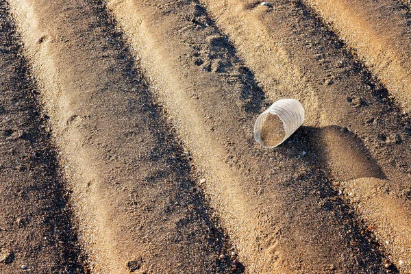 Botella de plástico roto ensuciando una playa de arena —  Fotos de Stock