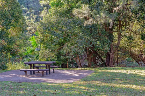 Piknik asztal és székek a gyönyörű buja vidéken — Stock Fotó