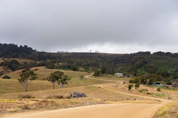 Estrada da sujeira do enrolamento através do país de fazenda de laticínios atingidos pela seca na Austrália — Fotografia de Stock