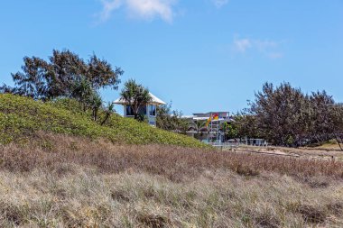 Kum tepelerinin arasında sörf yapan cankurtaran gözcüsü.