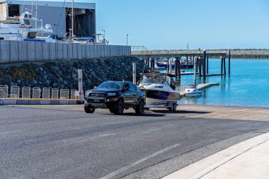 Mackay, Queensland, Avustralya - Haziran 2020: Balıkçı teknesini yat limanındaki eğlence amaçlı tekne rampasında suya indiriyor