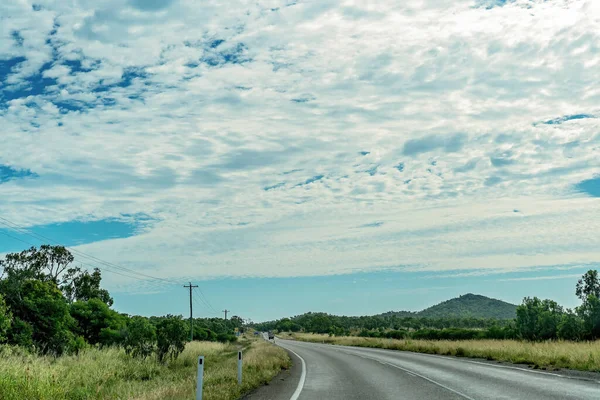 Australijska Wiejska Autostrada Pod Zachmurzonym Błękitnym Niebem — Zdjęcie stockowe