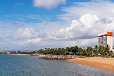 Yüksek katlı bir oteli olan kıyı kenarı manzarası okyanusa giden bir düzlüğe bakıyor.