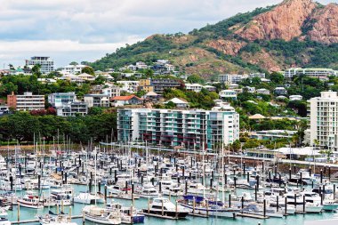 Townsville, Queensland, Avustralya - Haziran 2020: Şehirde pansiyonlarla çevrili bir marinada dinlenme botları ve arka planda pembe granit monolit bulunan tekneler