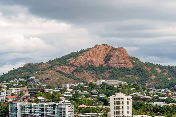 Townsville, Queensland, Avustralya - Haziran 2020: Miras listesindeki pembe Castle Hill 'in önündeki yüksek binalar ve konutlar