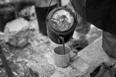 Volkanik bir milli parktaki Avustralya 'nın taşralı bir turizm beldesinde kamp ateşi konuğu çalılığından kahve dolduruluyor.