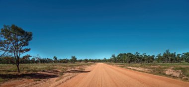 Avustralya kırsalında mühürsüz toprak ve tozlu bir yol.