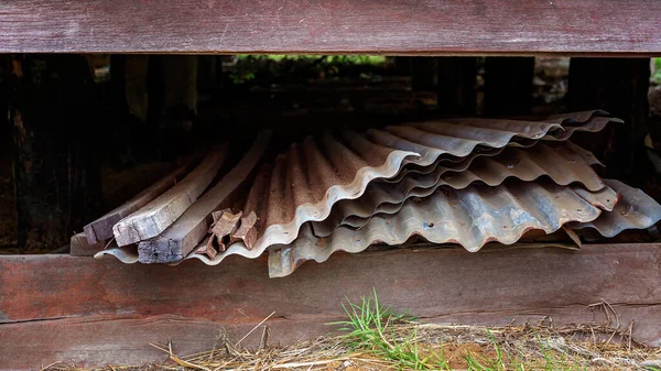 Sheets of corrugated iron and timber posts stored under an old abandoned country building