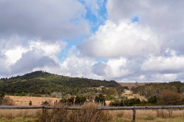 Dağlarda ahşap direkler ve dikenli tellerle çevrili otlak arazisi olan bir kırsal mandıra çiftliği.