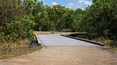 Modern bir kuyu, çalıların arasında piknik olanakları olan yürüyüş ve bisiklet pisti.