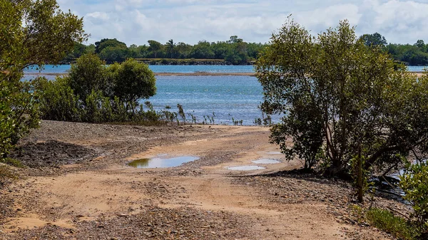 Dalgalar yükselen mavi bir su nehri. Tekneleri denize indirmek için çakıllı bir kıyıya bakıyor.