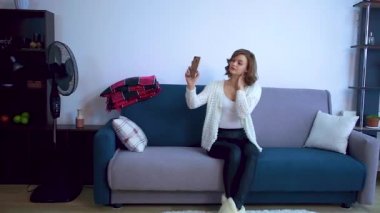 Kanepede oturan kız selfie çekiyor..