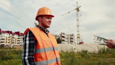 Erkek müteahhit, yaptığı iş için eline para alır..