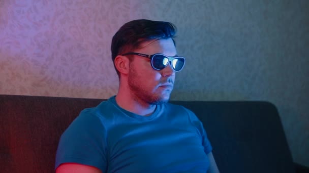 Un hombre se pone gafas 3D y emocionalmente mueve sus manos . — Vídeos de Stock