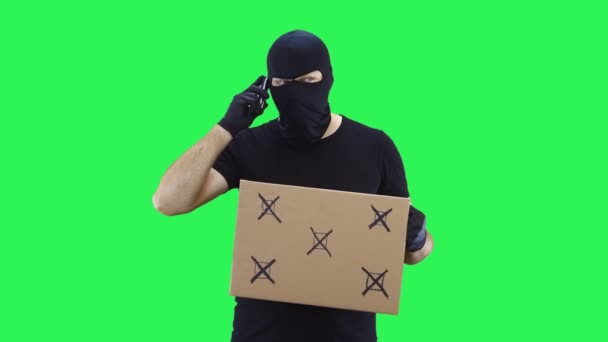 Человек в черной маске держит табличку для походов, зеленый фон экрана — стоковое видео
