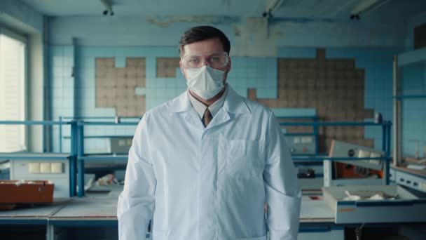 Retrato de un trabajador médico con un abrigo médico y máscara médica . — Vídeo de stock