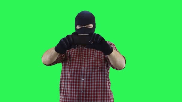 A man in a balaclava in a plaid shirt is recording video on a smartphone. — Stock Video