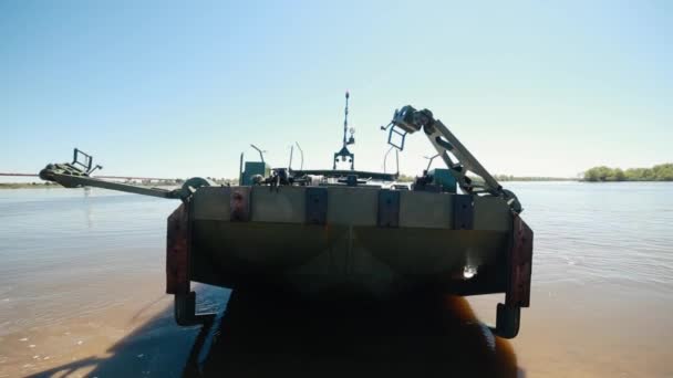 Un barco militar parado en la orilla del río descarta los camiones a ambos lados. . — Vídeos de Stock