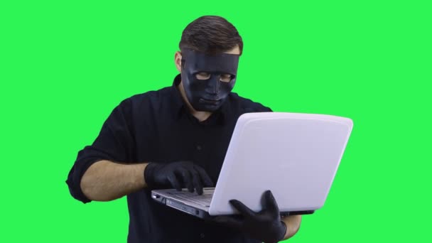 Ein maskierter Computerhacker bricht in ein Netzwerk ein. — Stockvideo