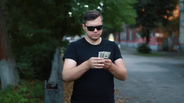 Ένας άντρας στο δρόμο παίρνει χρήματα από την τσέπη του και τα εξιστορεί.. — Αρχείο Βίντεο