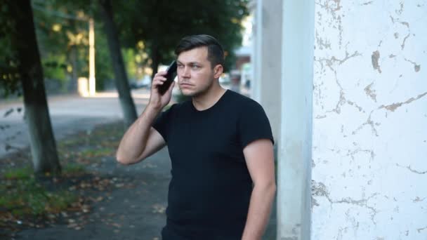 Ένας άντρας στο δρόμο να μιλάει στο τηλέφωνο.. — Αρχείο Βίντεο