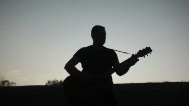 Akustik gitar çalan gitarist güçlüdür..