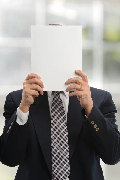 Empresário segurando um papel em branco — Fotografia de Stock
