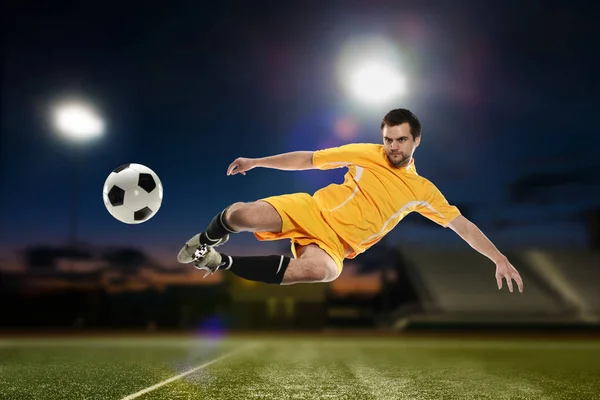 Jogador de futebol chutando a bola — Fotografia de Stock