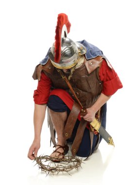 Roman soldier picking up a crown of thorns clipart