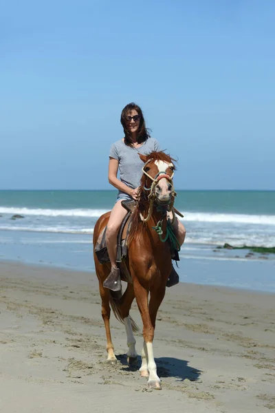 Femme chevauchant un cheval le long de la côte de l'océan — Photo