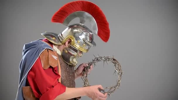 Римский Солдат Держащий Терновый Венец Сером Фоне — стоковое видео