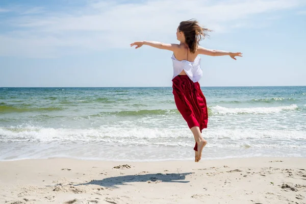 Schöne Mädchen in rotem Kleid am Meer. — Stockfoto