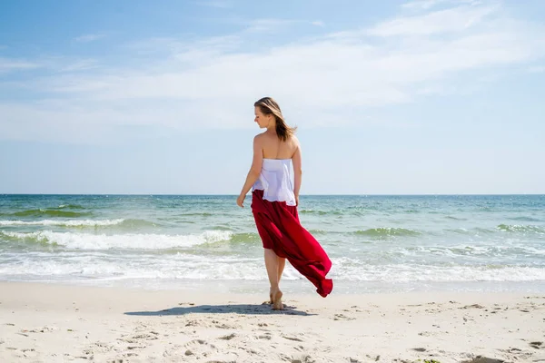 Beautiful girl in red dress by the sea. — Stock Photo, Image