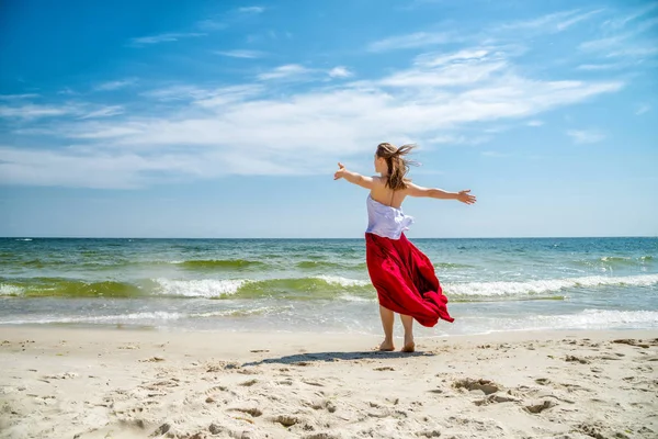 Bella ragazza in abito rosso in riva al mare . — Foto Stock