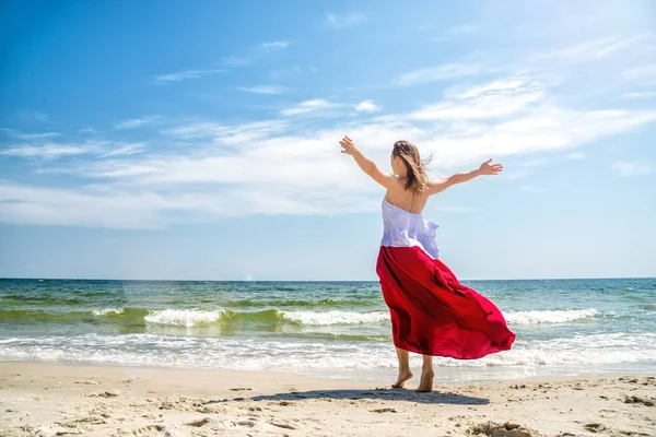 Bella ragazza in abito rosso in riva al mare . — Foto Stock