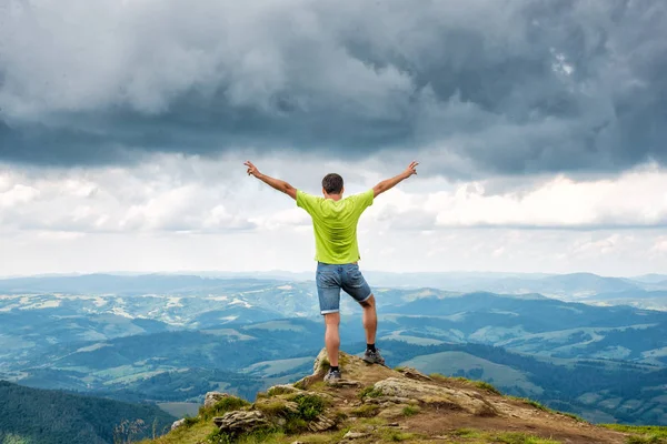 Hombre de pie en la cima de la montaña — Foto de Stock