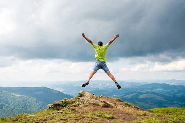 Man springen op de top van de berg — Stockfoto