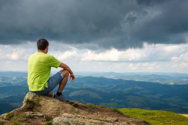 dağın zirvesine oturan adam