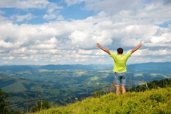 Hombre de pie en la cima de la montaña — Foto de Stock