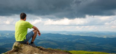 dağın zirvesine oturan adam