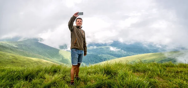 Homem de pé no pico da montanha — Fotografia de Stock