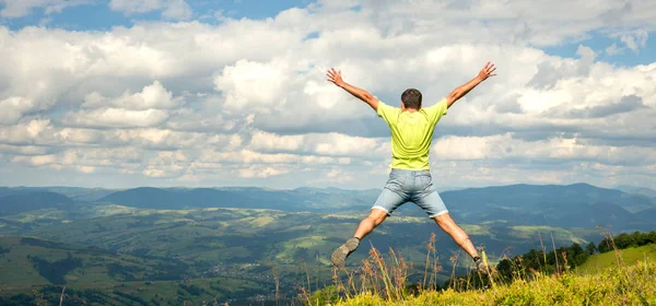 Man springen op de top van de berg — Stockfoto