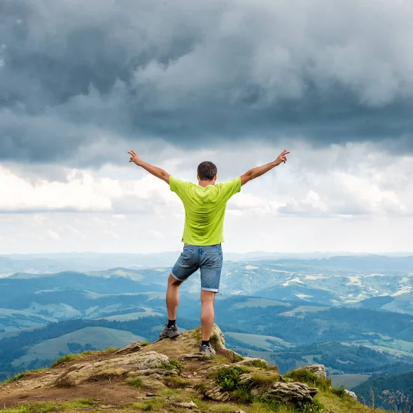 Hombre de pie en la cima de la montaña — Foto de Stock