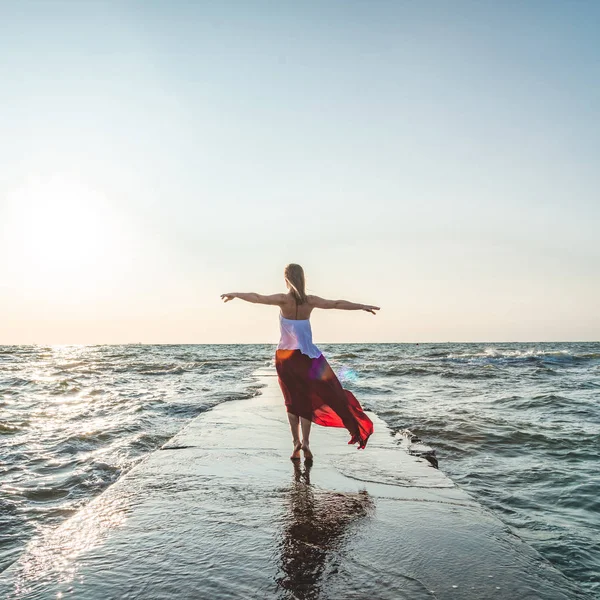 Mooi meisje in een rode jurk van de zee. — Stockfoto