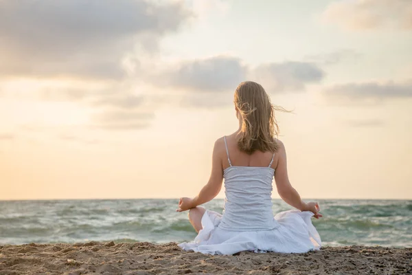 Женщина медитирует у моря — стоковое фото