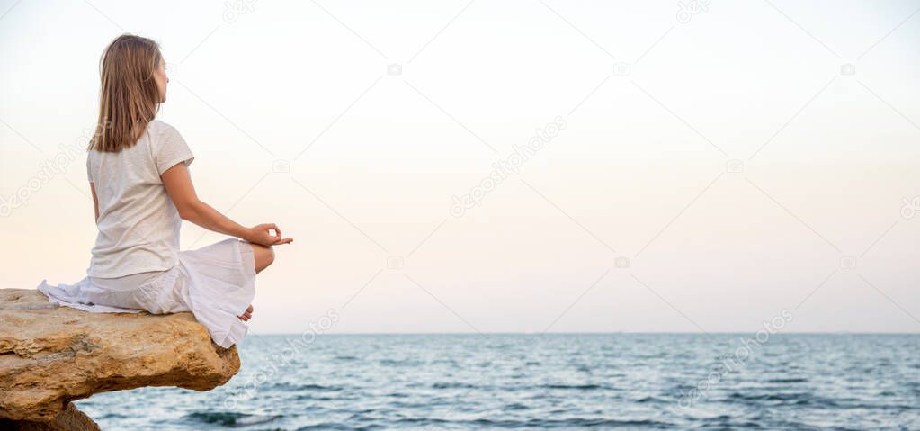 Woman meditating at the sea