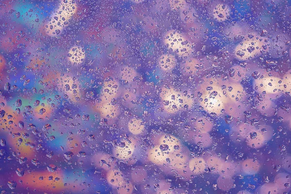 Pencerenin dışında farklı ışıklar camına yağmur damlaları