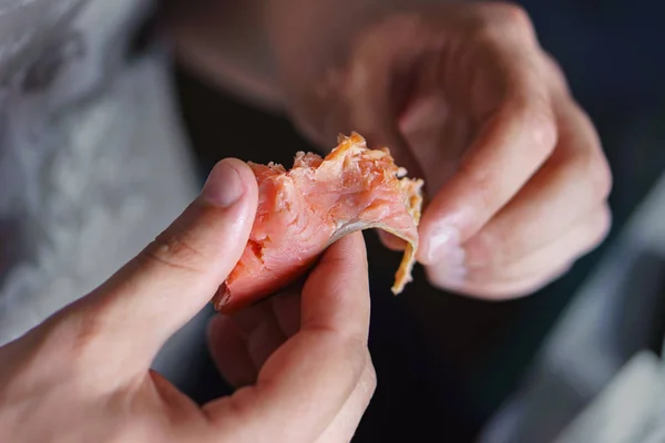Erkek bir parça kırmızı füme balık tutan eller