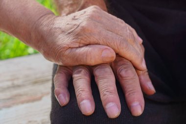 Yaşlı bir kadın ele yaşlı bir adamın elini üzerinde oturuyor