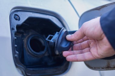 Erkek el gaz tankı açtı ve gaz tankı kapağı tutar